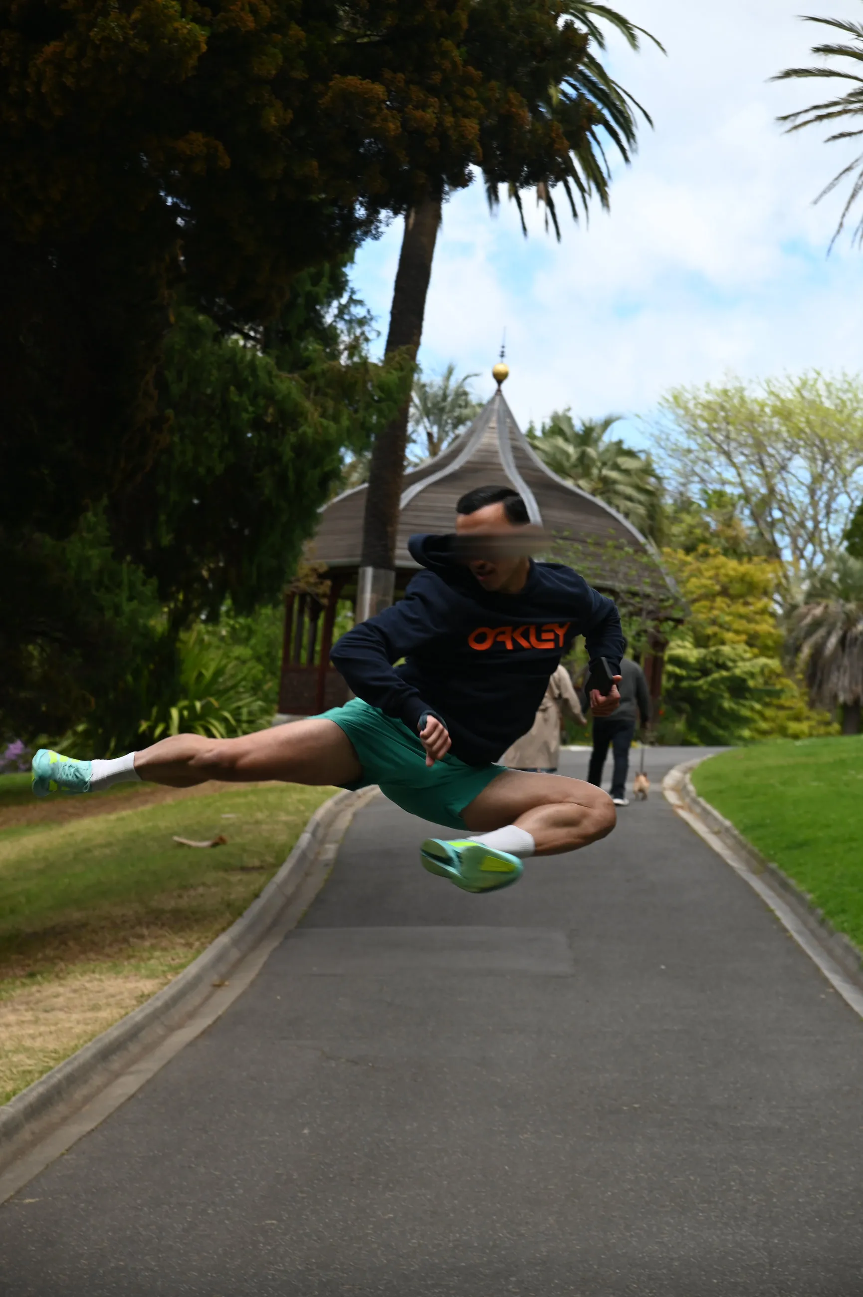 Me mid-air in an outdoor jump over a paved path