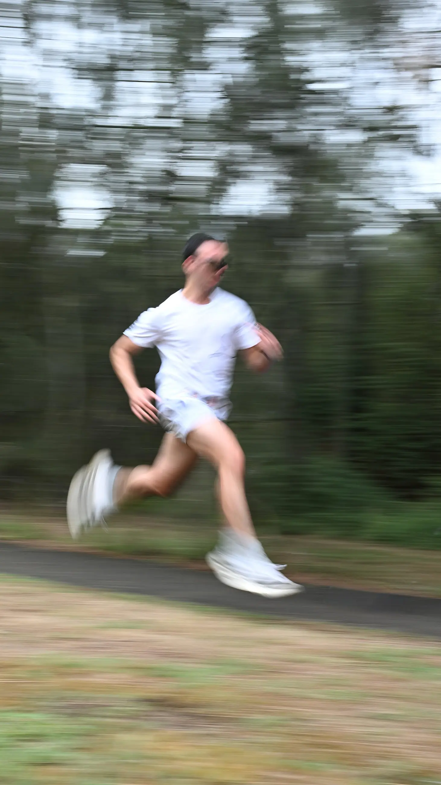Me running on an outdoor path in white training kit, with motion blur